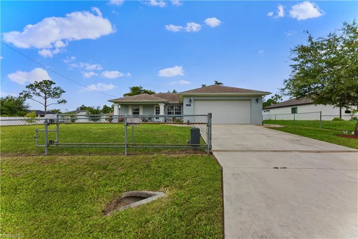 Ranch-style house with a garage and a front lawn