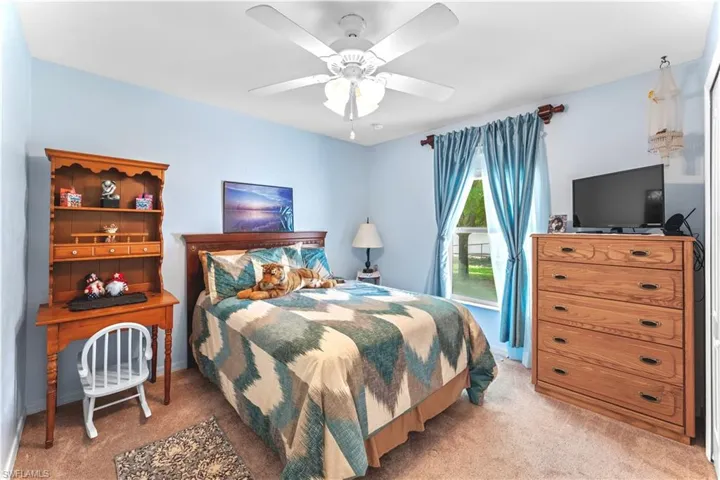 Carpeted bedroom featuring ceiling fan