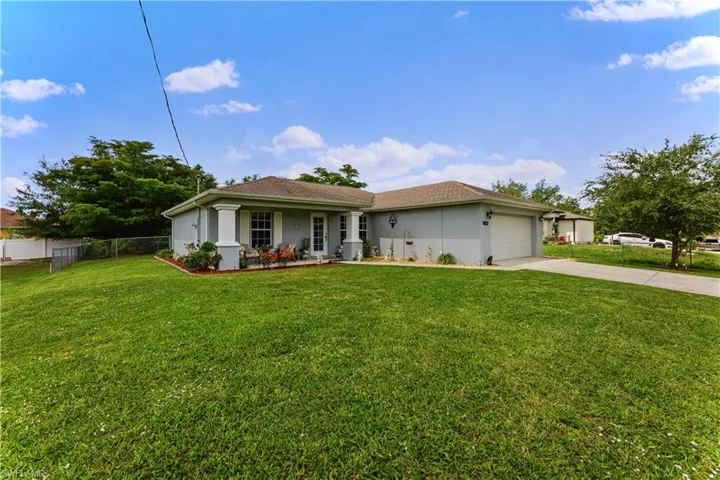 Single story home with a garage and a front yard