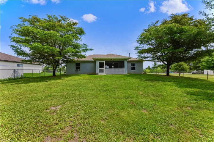 Back of house with a lawn
