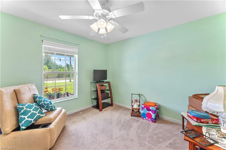 Living area featuring carpet flooring and ceiling fan