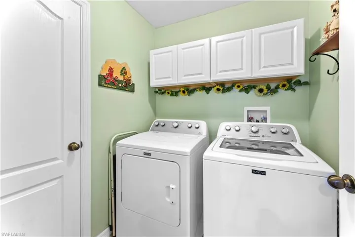 Laundry area with cabinets, washer hookup, and washing machine and clothes dryer