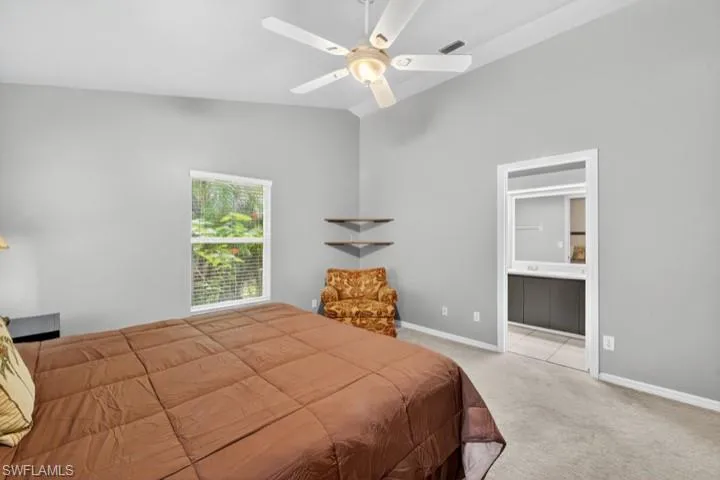 Carpeted King Size Primary Bedroom featuring lofted ceiling and a ceiling fan (Paint color is soft sage green)