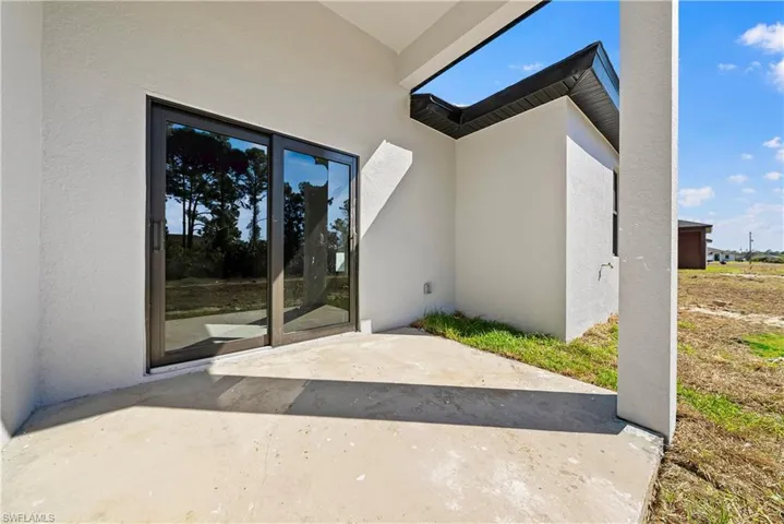 Property entrance with a patio and stucco siding