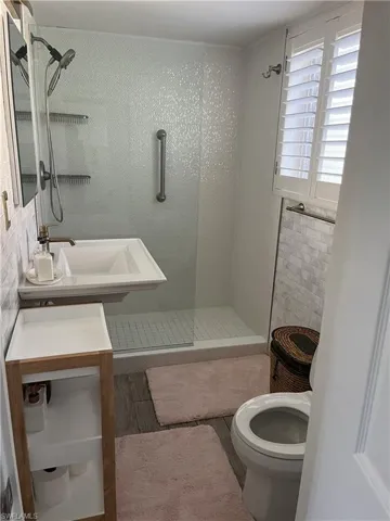Bathroom featuring a walk-in shower with a glass enclosure and white mosaic tile surround