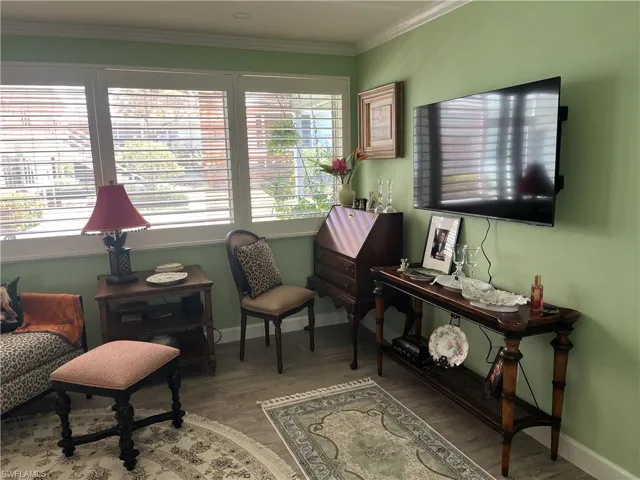 Living area featuring light green walls and wood-finish flooring