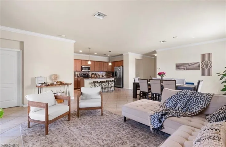 Living area featuring ornamental molding, light tile patterned floors, and recessed lighting
