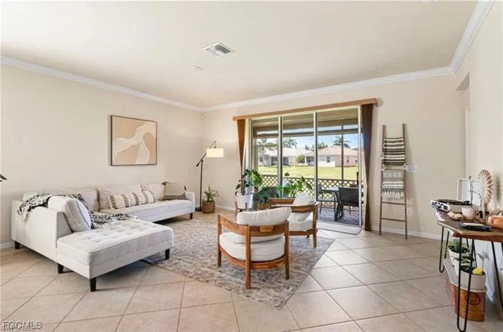 Living area with ornamental molding and light tile patterned floors