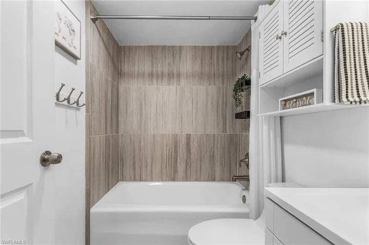 Bathroom featuring shower / bathtub combination, toilet, and vanity