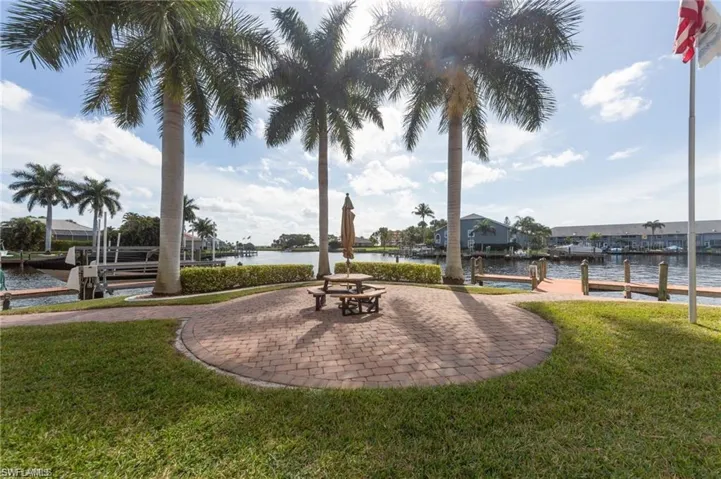 View of property's community featuring a lawn, a dock, and a water view