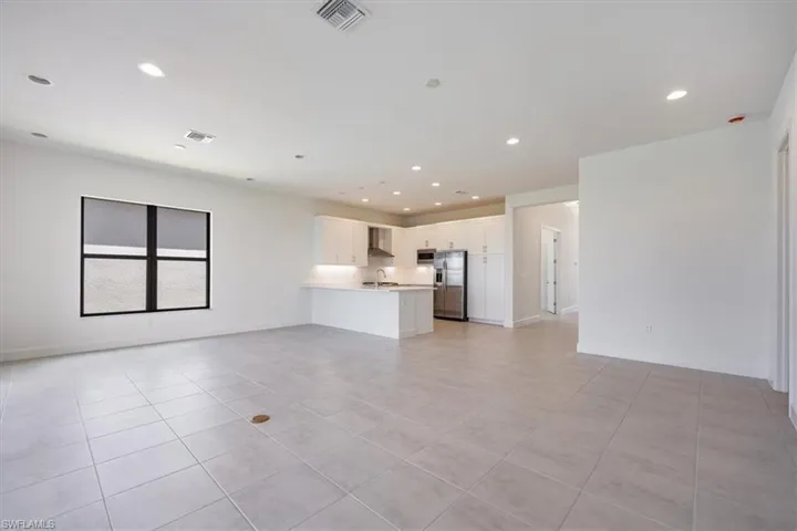 Unfurnished living room with light tile patterned floors and sink