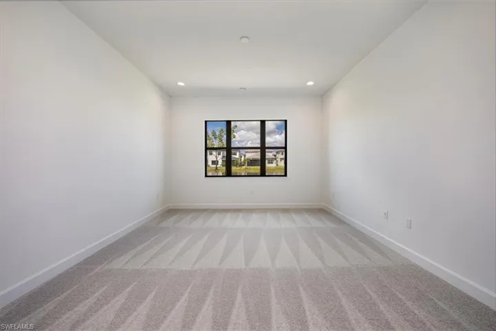 Empty room featuring light colored carpet