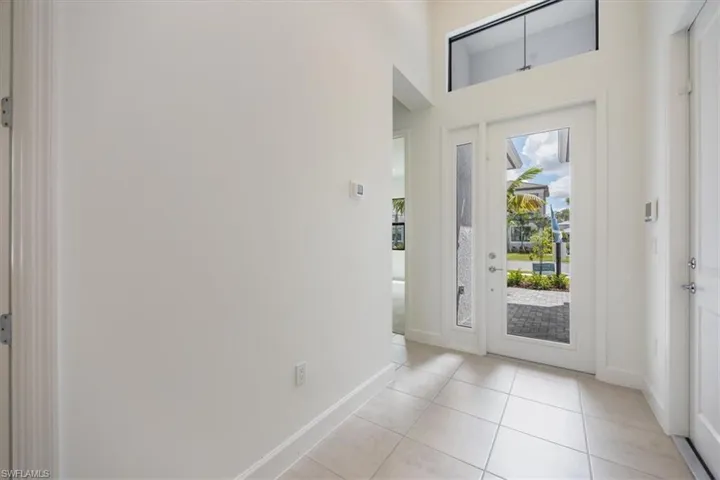 Doorway with light tile patterned flooring