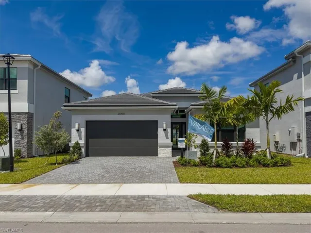 View of front of property with a garage and a front lawn