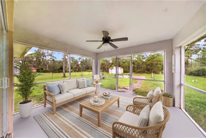Screened-in porch featuring a ceiling fan, painted concrete flooring, and full-height screen walls