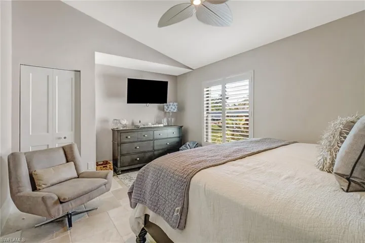 Bedroom featuring lofted ceiling, a closet, and ceiling fan