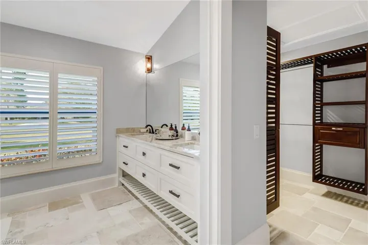 Full bathroom with double vanity and vaulted ceiling