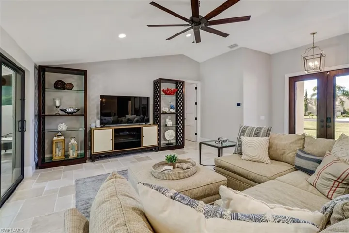 Living area featuring plenty of natural light, vaulted ceiling, recessed lighting, french doors, and ceiling fan