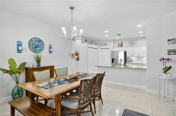 Dining area with light tile patterned floors, recessed lighting, and a chandelier