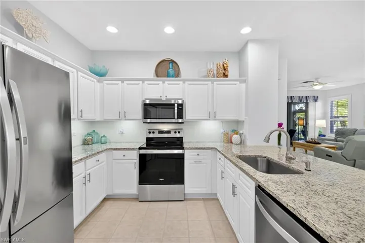 Kitchen with stainless steel appliances, backsplash, white cabinetry, and recessed lighting