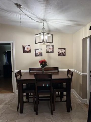 Dining area with a chandelier and a textured ceiling