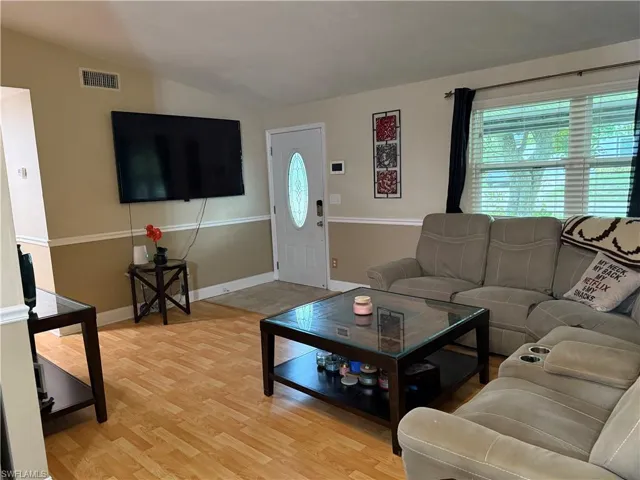 Living area featuring light wood-style flooring and vaulted ceiling