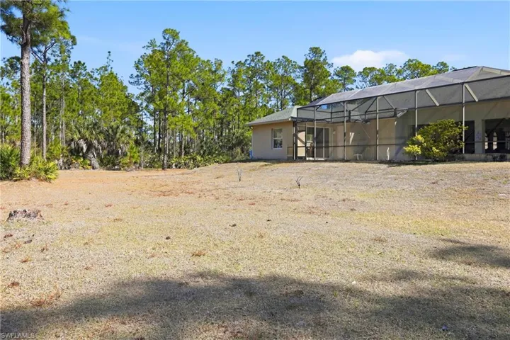 View of yard with a lanai and a sunroom