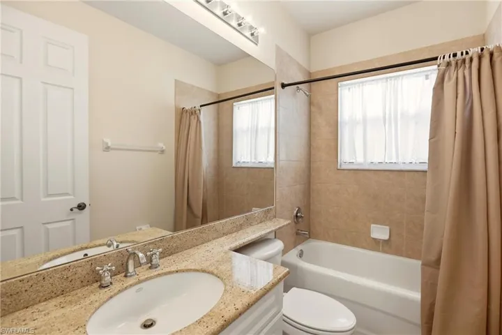 Bathroom featuring shower / tub combo with curtain and vanity