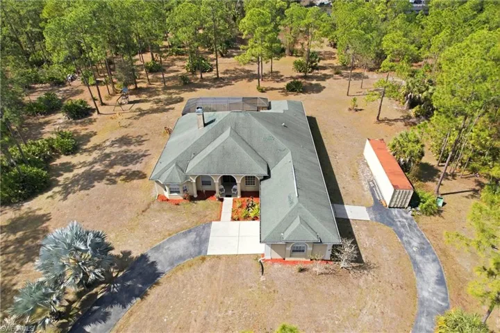 View from above of property featuring a tree filled landscape