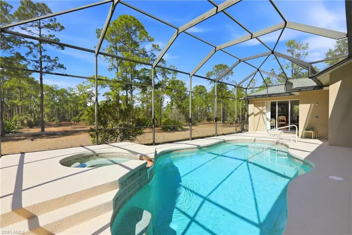 Combined pool / hot tub with a patio area, a sunroom, and glass enclosure