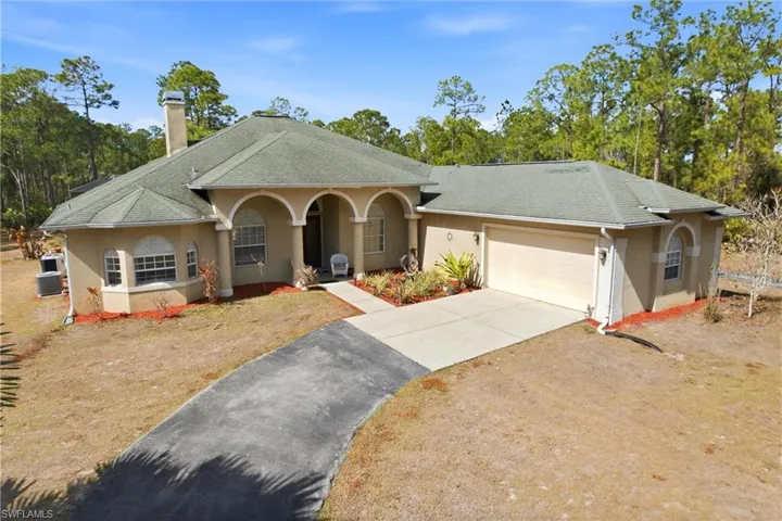 View of front of house featuring stucco siding, asphalt driveway, a garage, a shingled roof, and a chimney