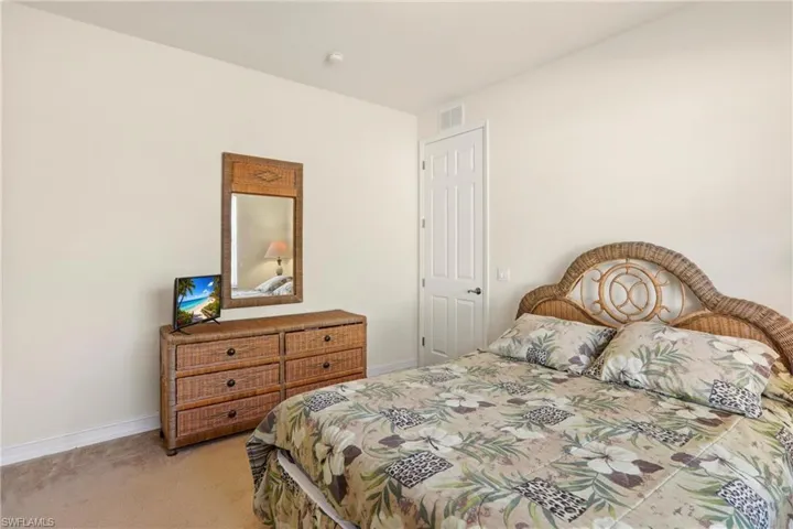 Bedroom featuring light colored carpet and baseboards