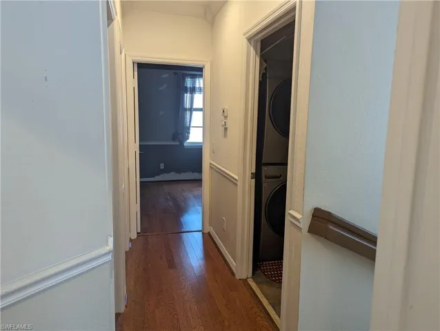 Hall featuring hardwood / wood-style flooring and stacked washer and dryer