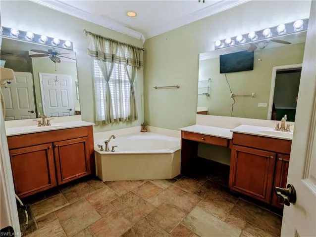 Bathroom with tile floors, dual vanity, ceiling fan, and a bath