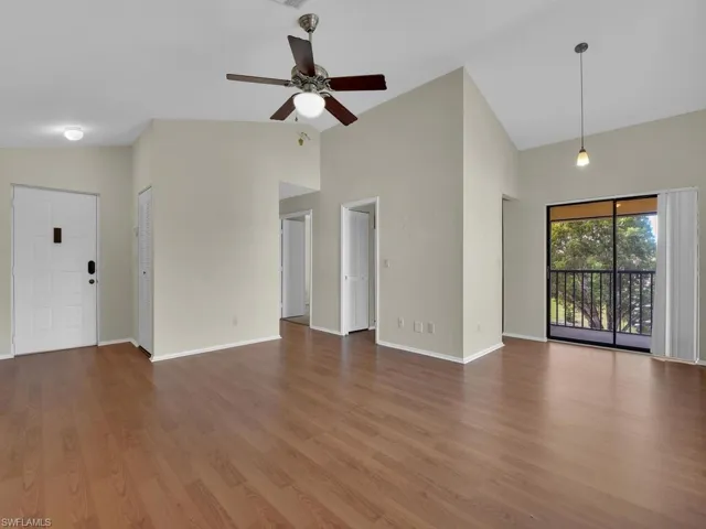 Unfurnished living room featuring vaulted ceiling, wood-type flooring, and ceiling fan