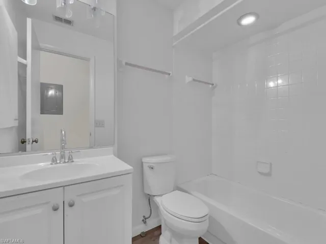 Full bathroom featuring tiled shower / bath, vanity, and toilet