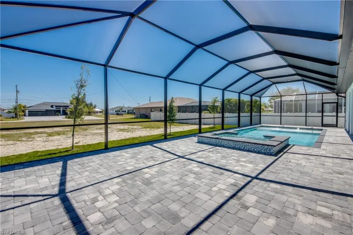 View of pool featuring a residential view, a pool with connected hot tub, a lanai, and a patio area