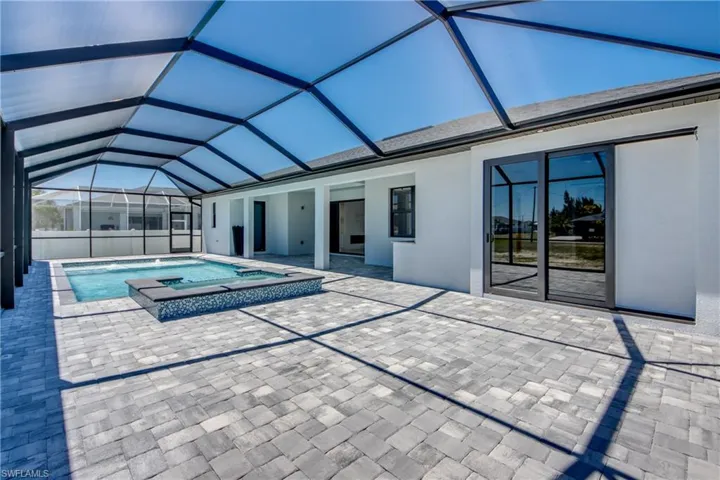 Pool featuring a patio, a lanai, and an in ground hot tub