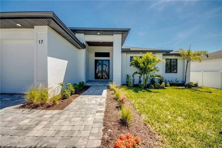 Property entrance featuring fence, stucco siding, and a yard