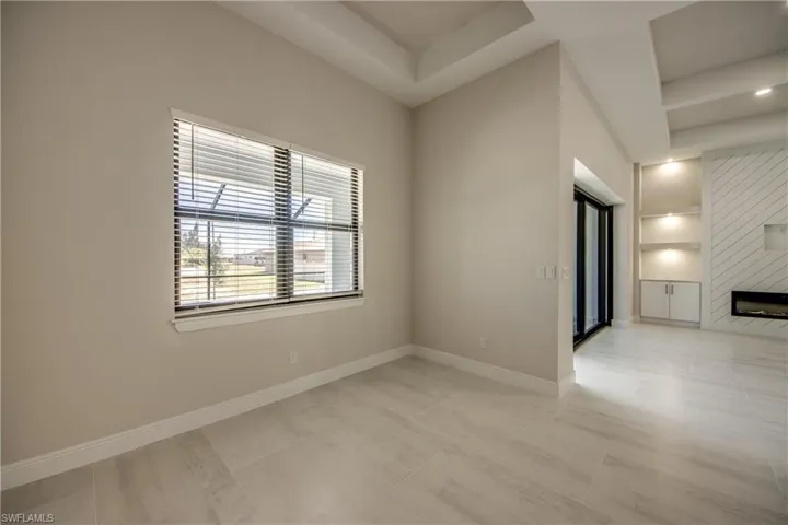 Empty room with baseboards, a fireplace, and built in features