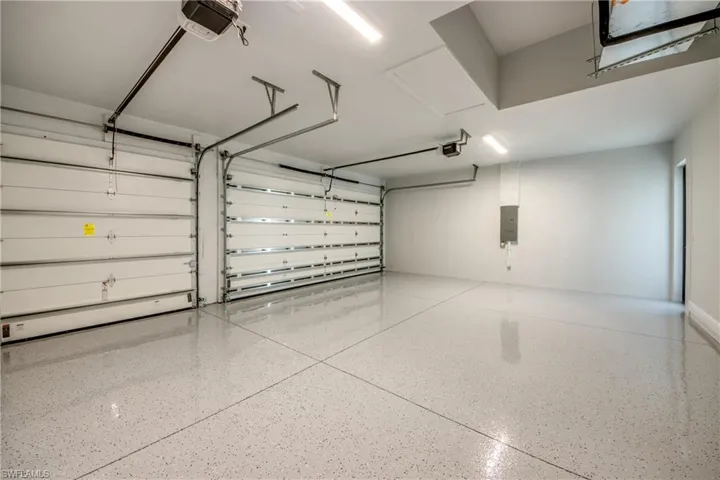 Garage featuring electric panel and a garage door opener