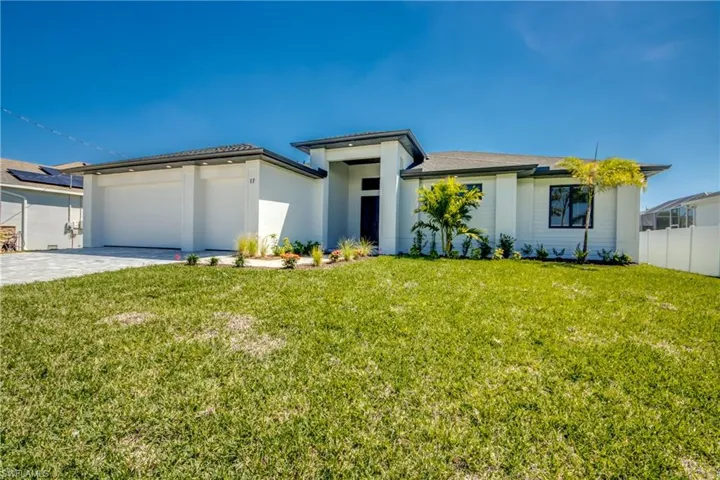 Prairie-style home with driveway, a garage, fence, and a front yard