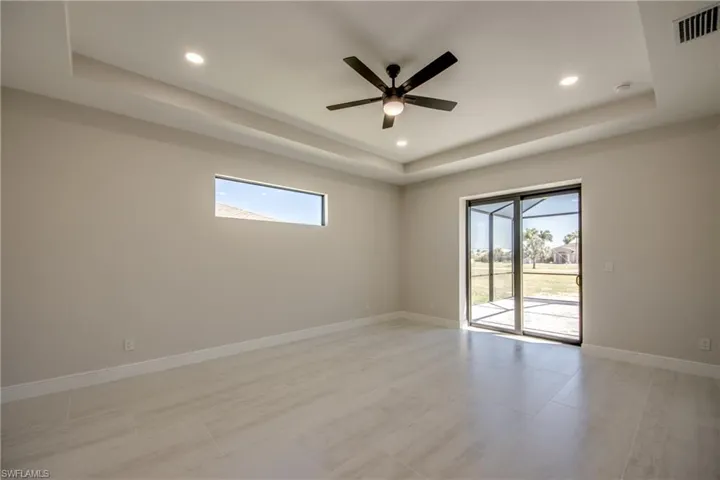 Spare room with a raised ceiling, baseboards, and visible vents