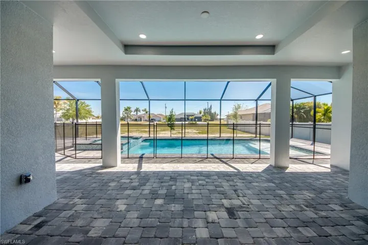 View of swimming pool featuring a pool with connected hot tub, glass enclosure, and a patio
