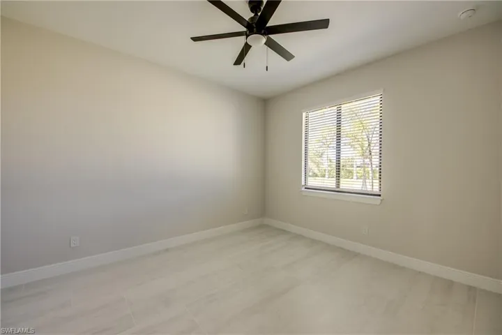 Unfurnished room with a ceiling fan and baseboards