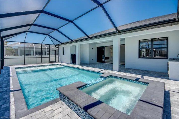 View of pool featuring a pool with connected hot tub, a lanai, and a patio area