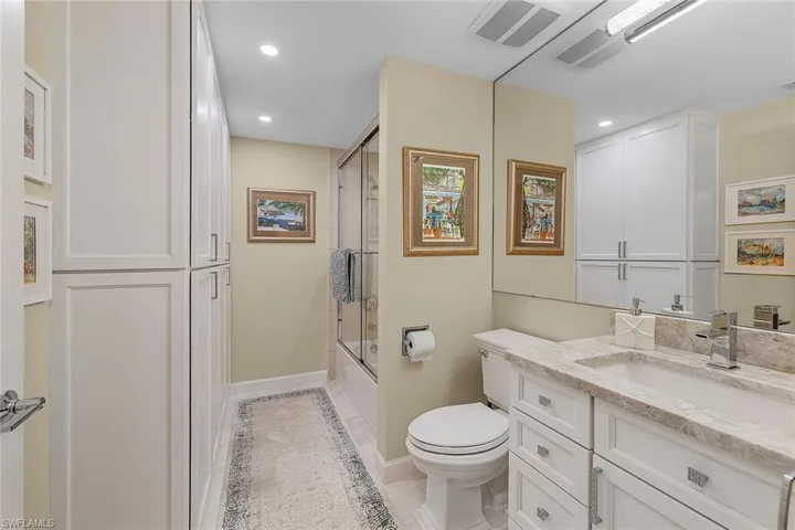 Full bath featuring vanity, enclosed tub / shower combo, recessed lighting, and light tile patterned flooring
