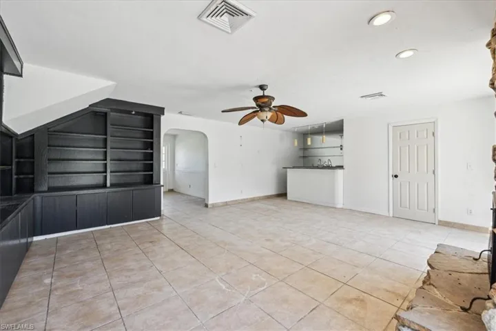 Unfurnished living room with ceiling fan and light tile patterned flooring