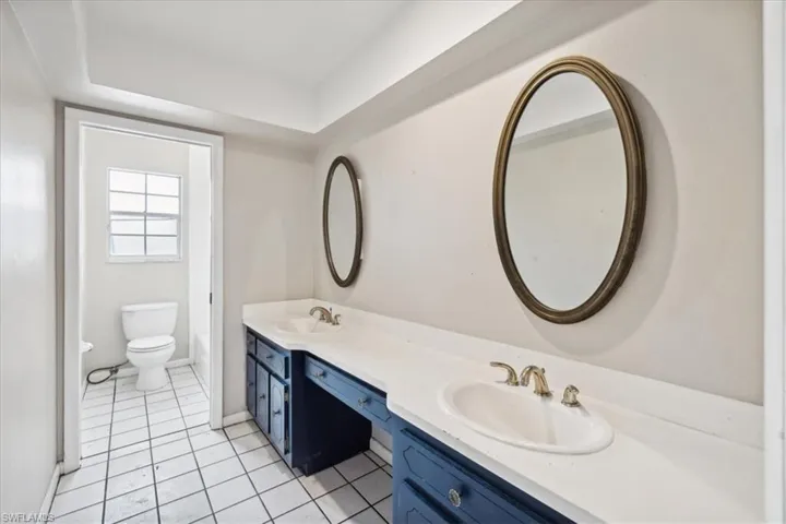 Bathroom with vanity, toilet, and tile patterned flooring
