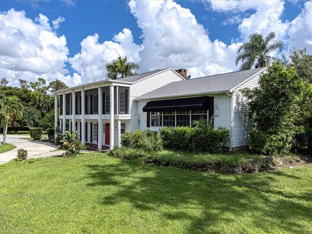 View of front of house featuring a front lawn and a sunroom